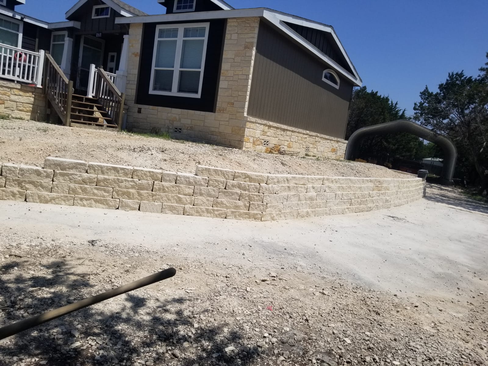 A completed stone retaining wall in a landscaped Cincinnati yard